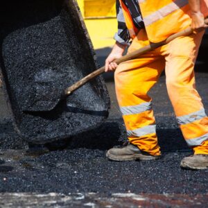 worker scooping asphalt