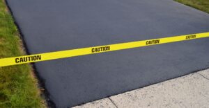 newly paved driveway with caution tape in front of it.