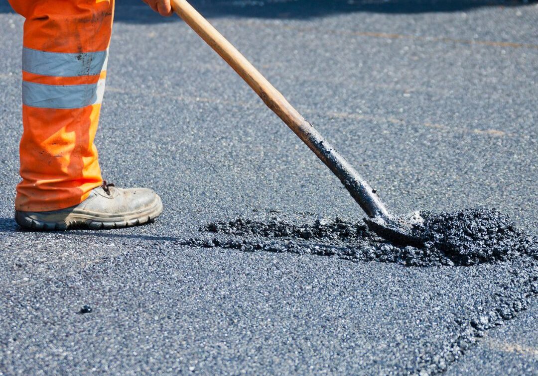 Man repairing asphalt.